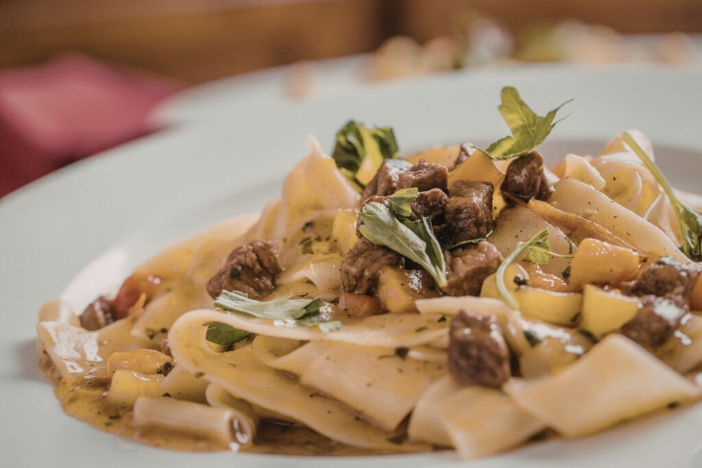 Plate of pappardelle with beef ragu and fresh herbs